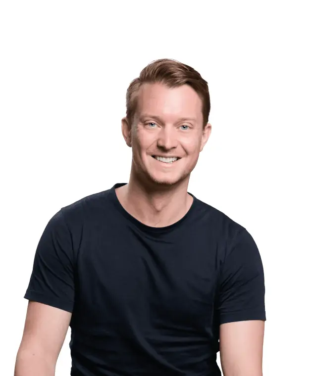 A smiling man with closely cropped hair wearing a black t-shirt against a white background.